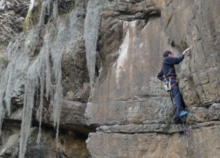 hombre sujeto con cuerdas escalando